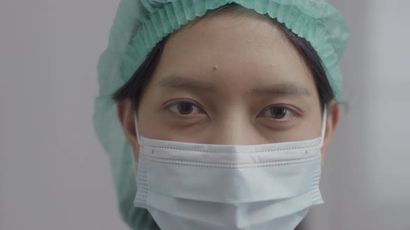 Close Up Asian nurse with face mask in medical protective uniform working in the hospital.