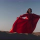 An Asian Woman in a Red Dress Gets Into a Pose on One Leg on Sand Dunes - VideoHive Item for Sale