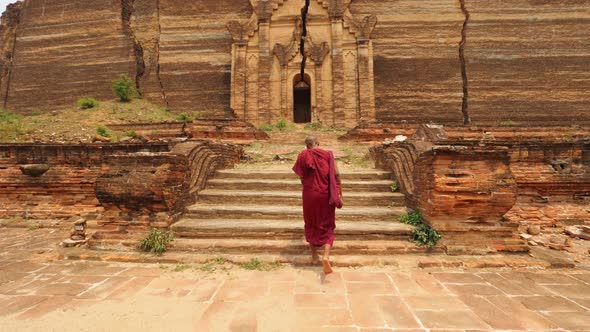 Asian Monk Walking In Front Of Burmese Ancient Buddhist Temple. Slow Motion Footage. Mandalay