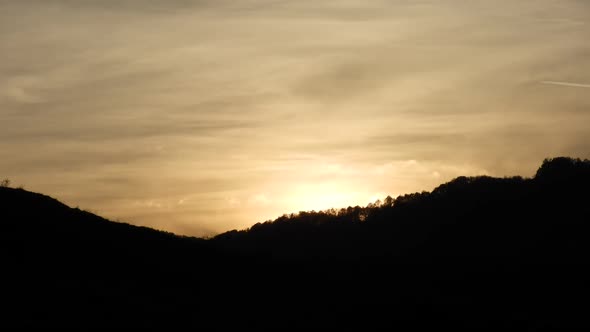 Sunset time lapse with clouds and trees silhouette and airplanes flying by