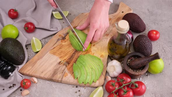 Healthy Food Nutrition Cuisine Recipes Cutting Slicing Fresh Avocado Fruit with Knife on a Wooden