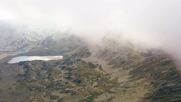 Incredible aerial shot next to cliffs with a lake in the foreground.