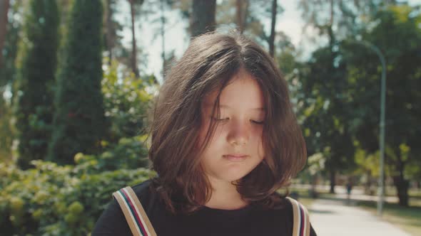 Portrait of Cute Elementary Age Girl Expressing Sadness Outdoors