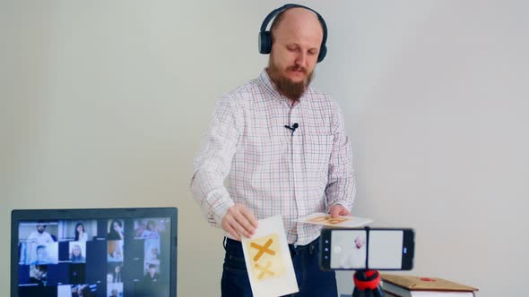 A Bald Man with a Beard Conducts Distance Learning Online the Study of Alphabet Uses Flashcards with