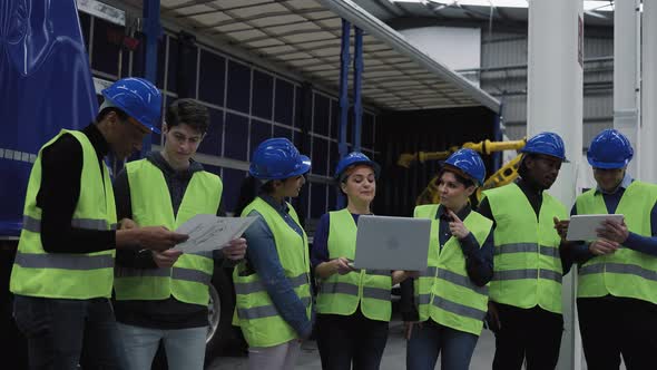 Team of multiracial engineers working in robotic factory - Tech industrial concept