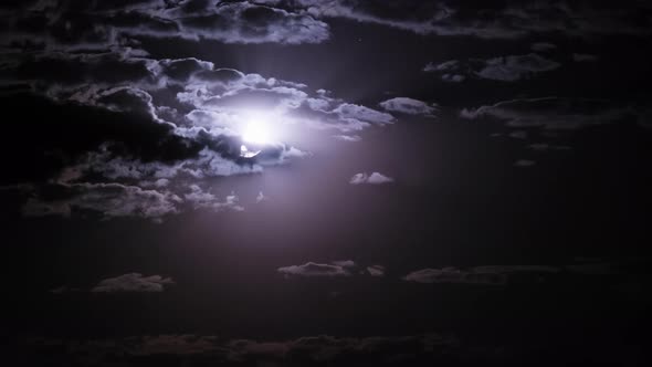 Timelapse of Moon Moves in the Night Sky Through Dark Clouds