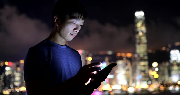 Asian man use of mobile phone at night 