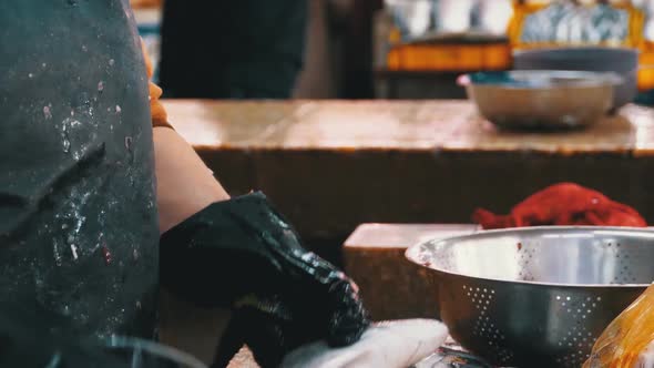 Cutting Fish in Market Stall. Woman Manual Cleaning and Cuts Fresh Fish