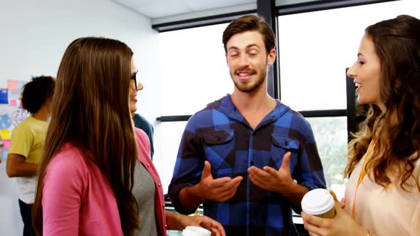 Happy graphic designers interacting while having coffee