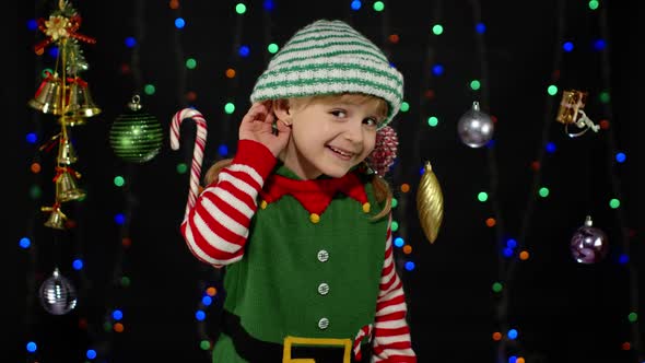 Girl in Christmas Costume Keeps Hand Near Ear Tries To Overhear What Present Parents Going To Give