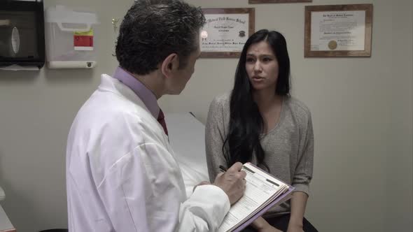 Woman talking to doctor about symptoms.
