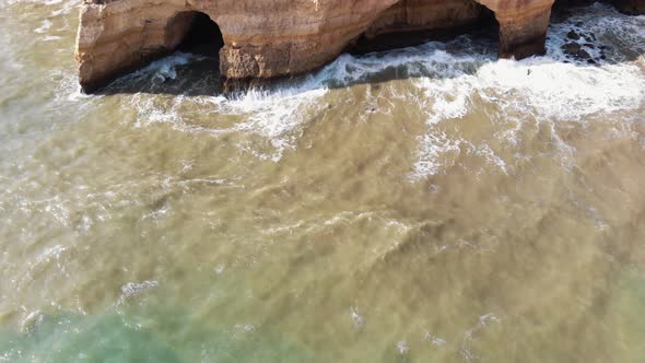 Caves in Benagil coast in Algarve, Portugal - Tilt up Reveal Aerial shot