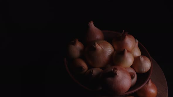 Pile of Whole Bulbs of Raw Onion in Ceramic Bowl on Table