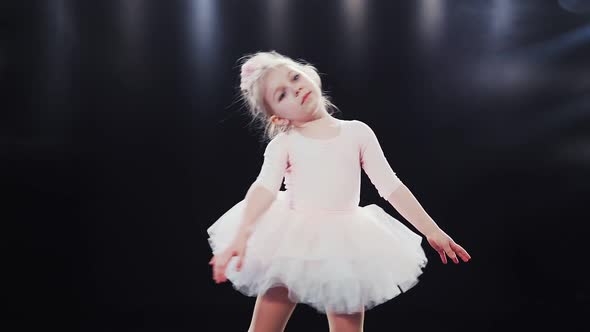 Little Girl Ballerina Caucasian Appearance in a Pink Tutu Dances on Stage