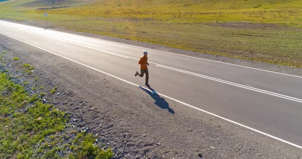 Low Altitude Flight in Front of Sporty Man at Perfect Asphalt Road