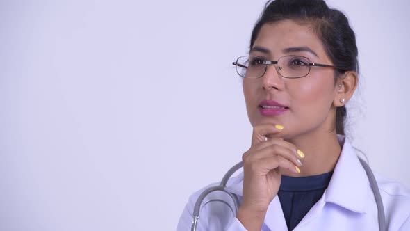 Face of Young Happy Persian Woman Doctor Thinking