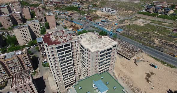  Construction work on top of building. Aerial view  Crane and building construction site.