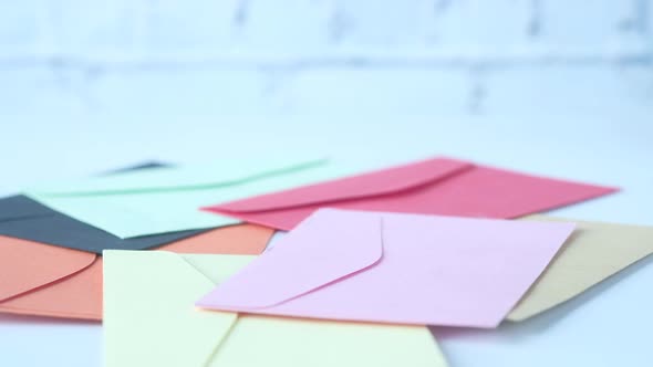 Red Rose on Many Colorful Envelope on Table