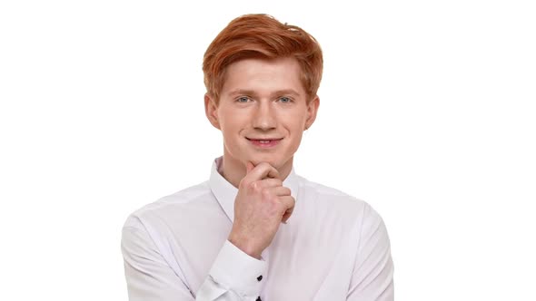 Young Handsome Caucasian Ginger Man Calmly Standing on White Background and Slowly Waving Hand in
