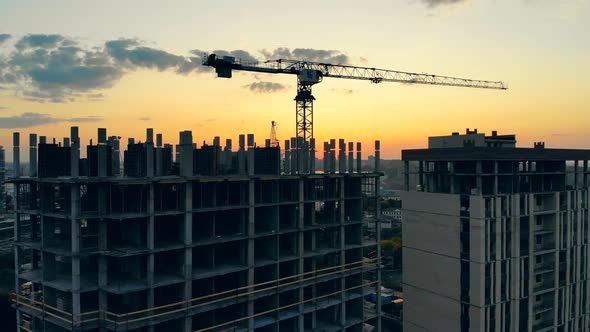 Building Machinery and High-rise Houses in Progress at Sunset