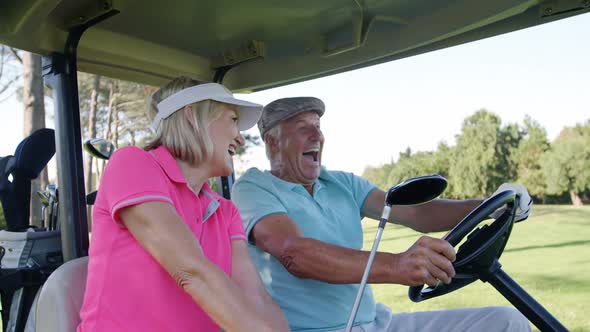 Two golfers driving in their golf buggy