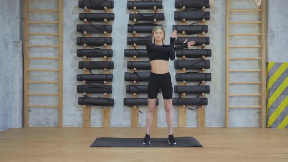 Young Girl Doing Hand Warm-Up for Workout, Stretching Muscles for Training in the Gym