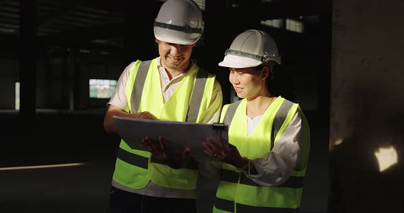 Industrial Engineers In Hard Hat Wearing Safety Jacket Working In The Building Site.