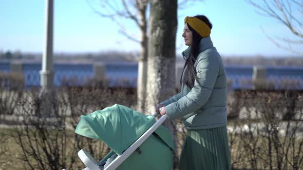 Woman Walking Through the Park with a Pram