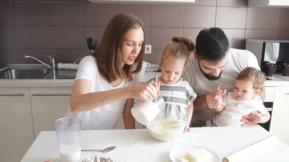 United Young Family Concentrated on Cooking Process