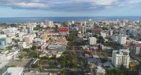 drone flies towards Ocean over busy Road surrounded by skyscrapers In Santo Domingo Dominican Republ