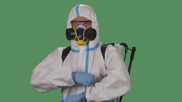 Portrait Male in a Protective Suit, Safety Glasses, Gloves and a Respirator Looks Confidently Into