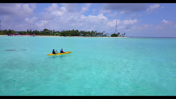 Teenage lovers sunbathe on tranquil tourist beach holiday by blue ocean with white sand background o