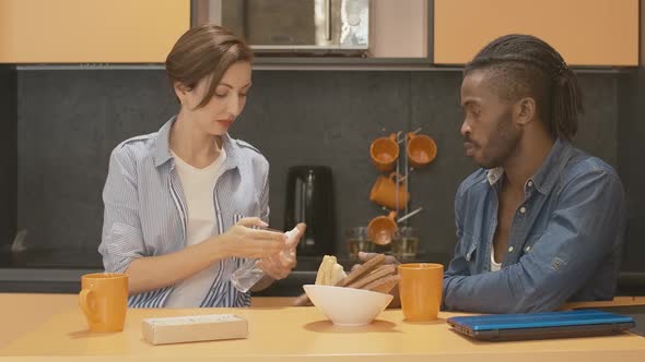 Portrait of Young Interracial Couple Disinfecting Hands Before Meal in Kitchen. African American Man