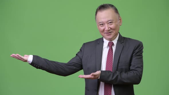 Mature Japanese Businessman Showing Something