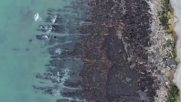 Top down aerial shot of white cliffs of dover beach blue water