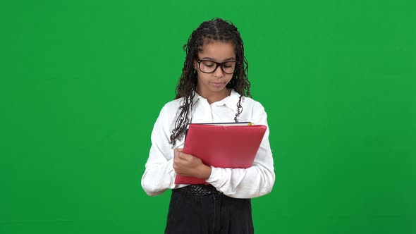 Portrait of Nerd African American Teen Girl in Eyeglasses Looking Through Notes in Workbook Sighing