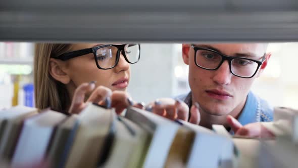 Students At Library Searching Learning Books On Bookshelves