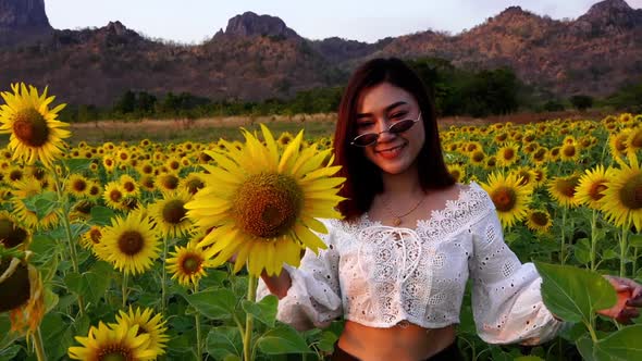 slow-motion of cheerful woman walking and enjoying with sunflower field