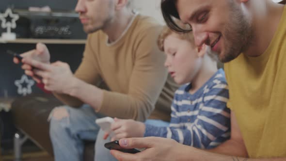 Slowmo of Same-Sex Couple and Boy Using Gadgets