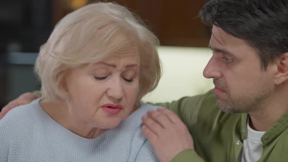 Closeup Stressed Senior Woman Grieving As Adult Man Talking Hugging Parent Supporting