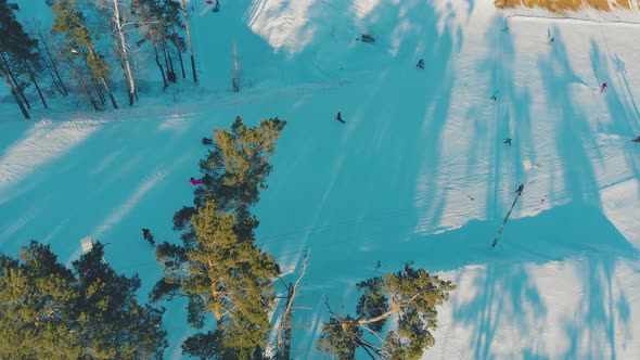 People Go Skiing and Ride Snowboards at Winter Resort Aerial