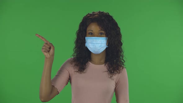 Portrait of Beautiful African American Young Woman in Medical Protective Face Mask Looking at Camera