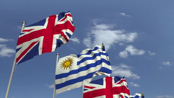Flags of Uruguay and the United Kingdom Against Blue Sky