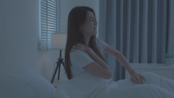 Asian beautiful sick girl in pajamas getting up from sleep in bedroom.