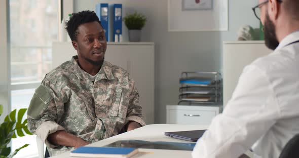 Afroamerican Military Officer Shaking Hands with Doctor in Clinic Office