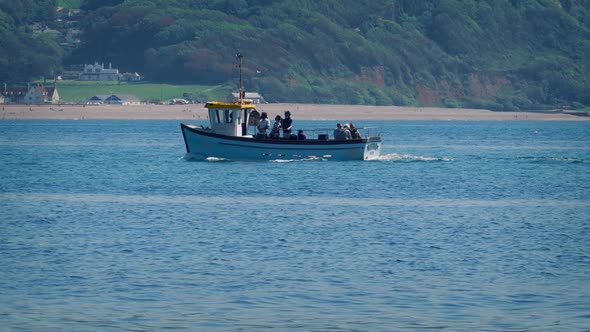 Fishing Boat Passes Near Beach On Sunny Day