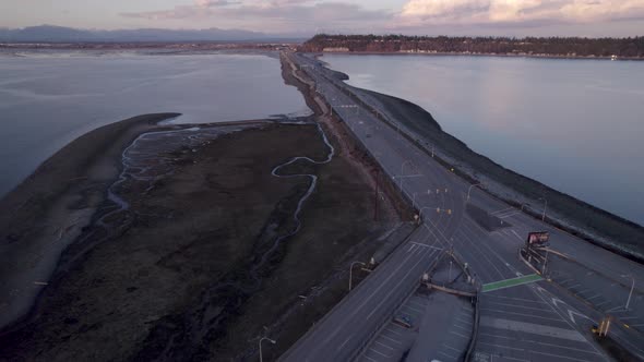 Aerial scenic road crossing the ocean connecting mainland, traffic cars driving fast on coastline hi