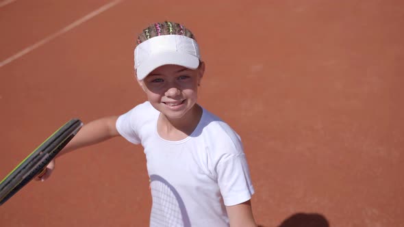 A Young Tennis Player Serves in a Tennis Game