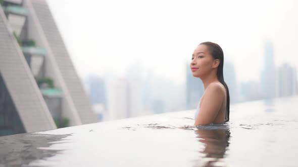 Young asian woman enjoy around outdoor swimming pool for leisure