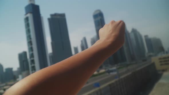 Female Hand Against the Background of Skyscrapers